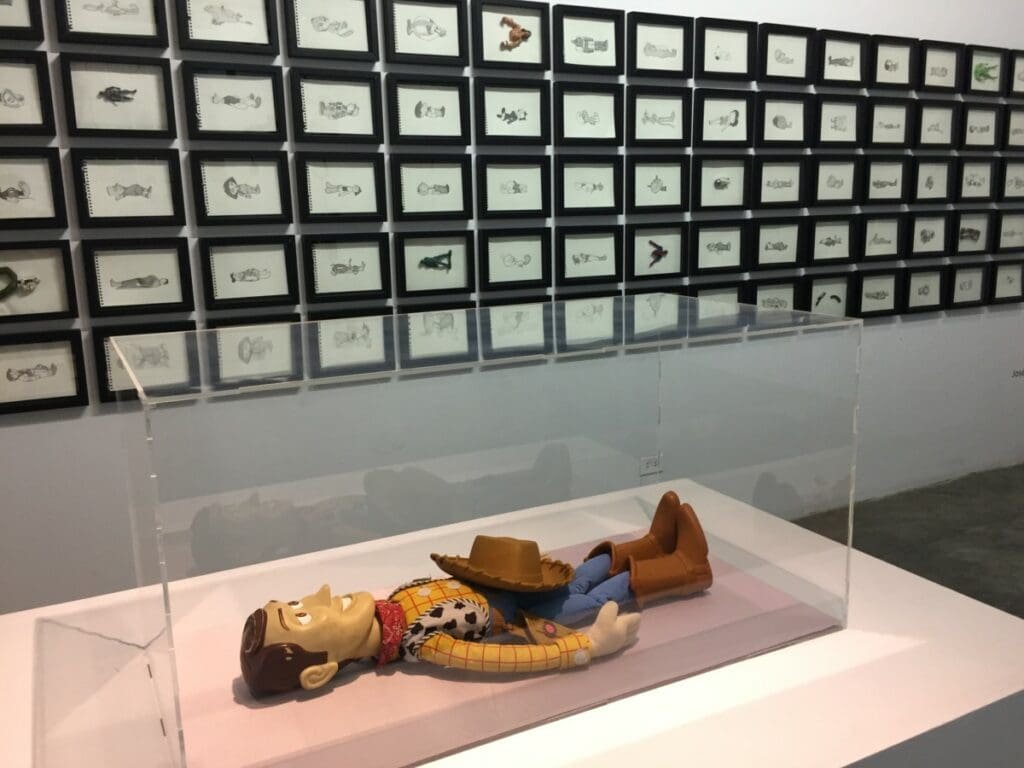 Sculpture de Woody (Toy Story) exposée devant dessins encadrés à la Factoría Habana.