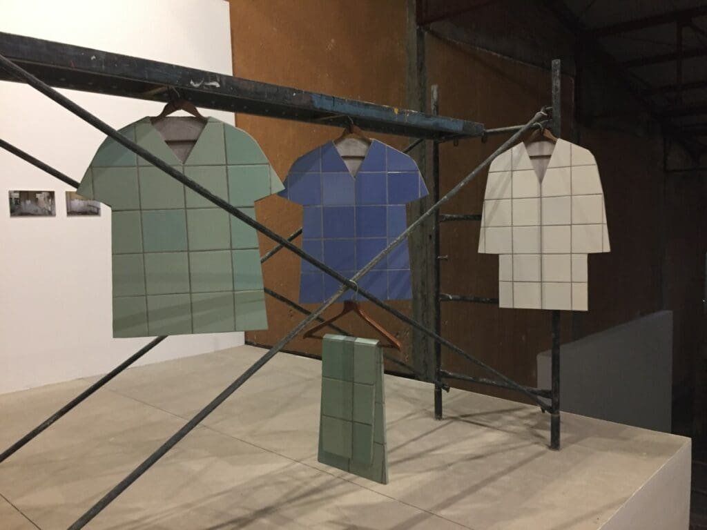 Installation de Zhanna Kadyrova: Tuniques en carrelage suspendues sur échafaudage.
