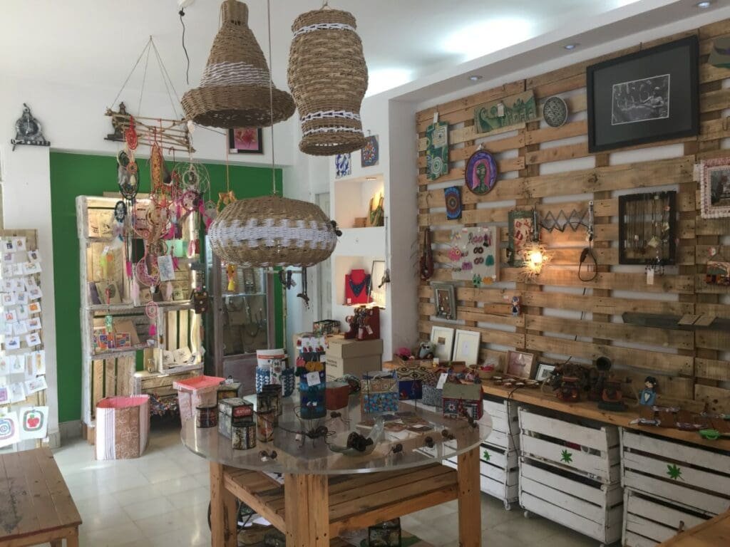 Intérieur galerie artisanale La Libertija à La Havane avec luminaires osier et mur palettes.
