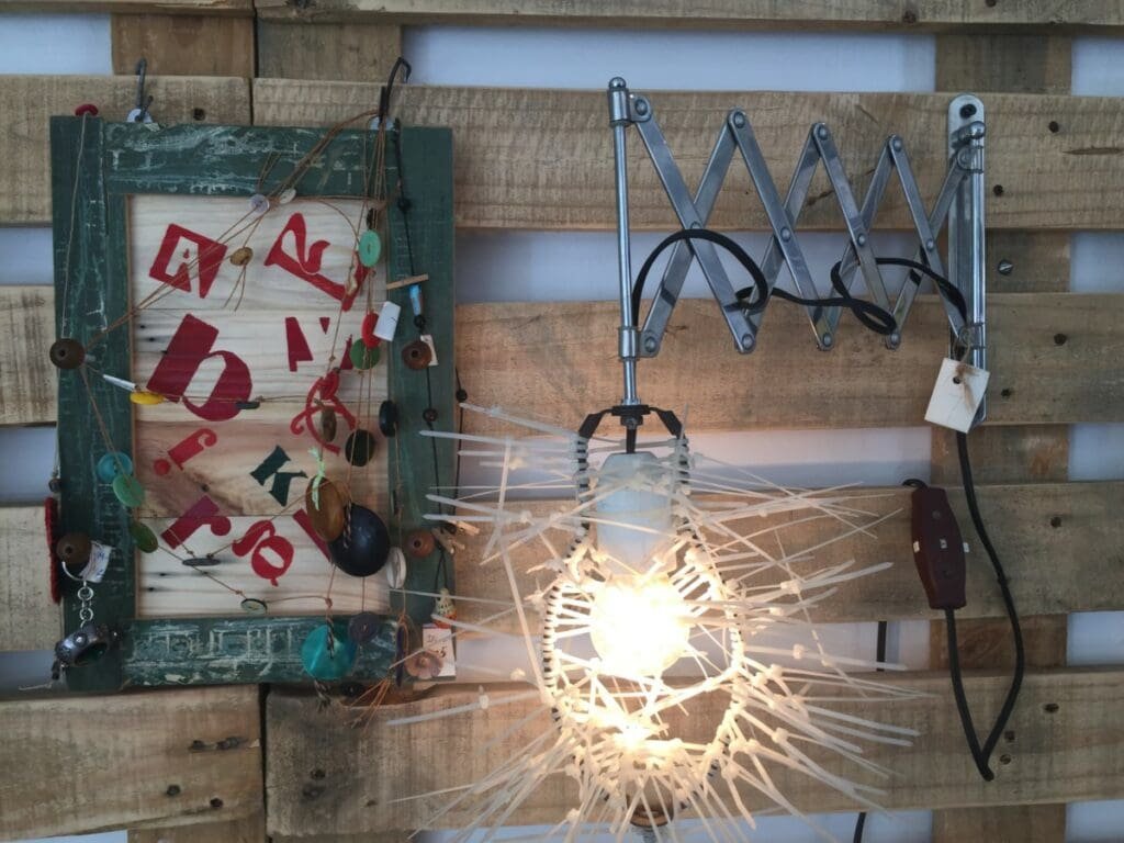 Installation artistique murale recyclée avec lampe accordéon et cadre décoré à La Libertija, Cuba.