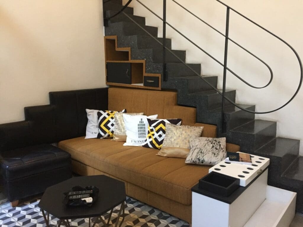 Intérieur boutique-hôtel Malecon 663, canapé et escalier en granit noir.