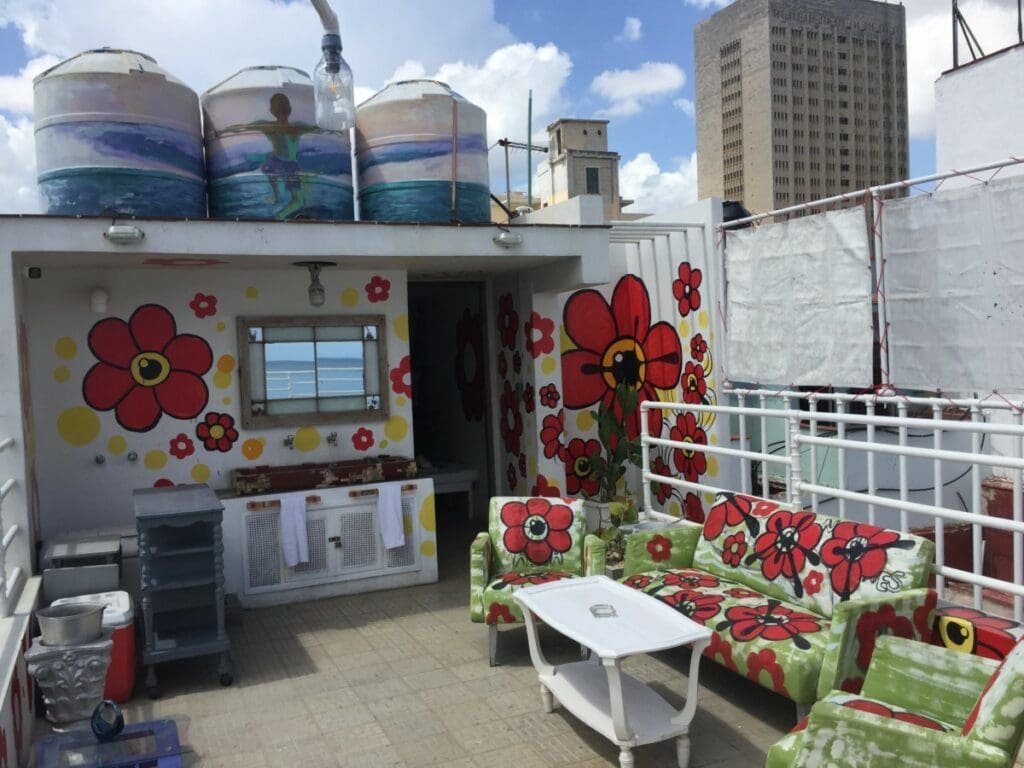 Terrasse de l'hôtel Malecon 663 à La Havane avec mobilier et murs décorés de fleurs.