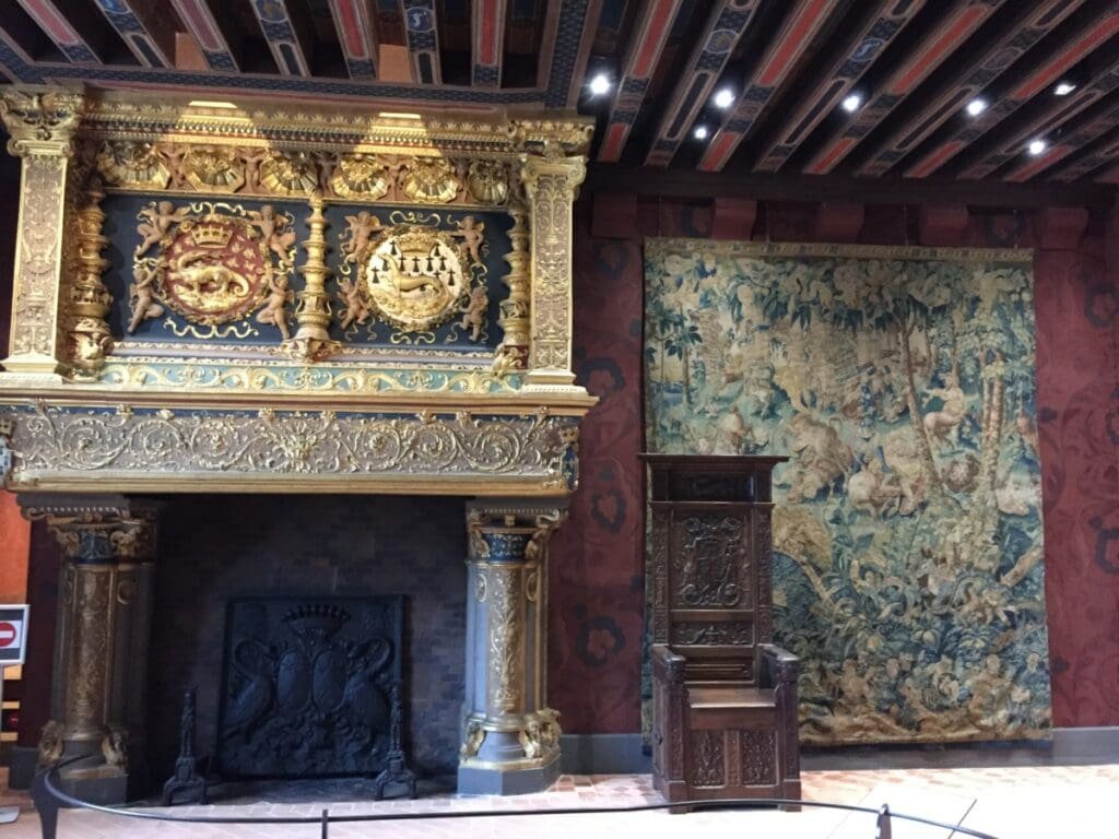 Cheminée Renaissance ornée et tapisserie murale au château de Blois.