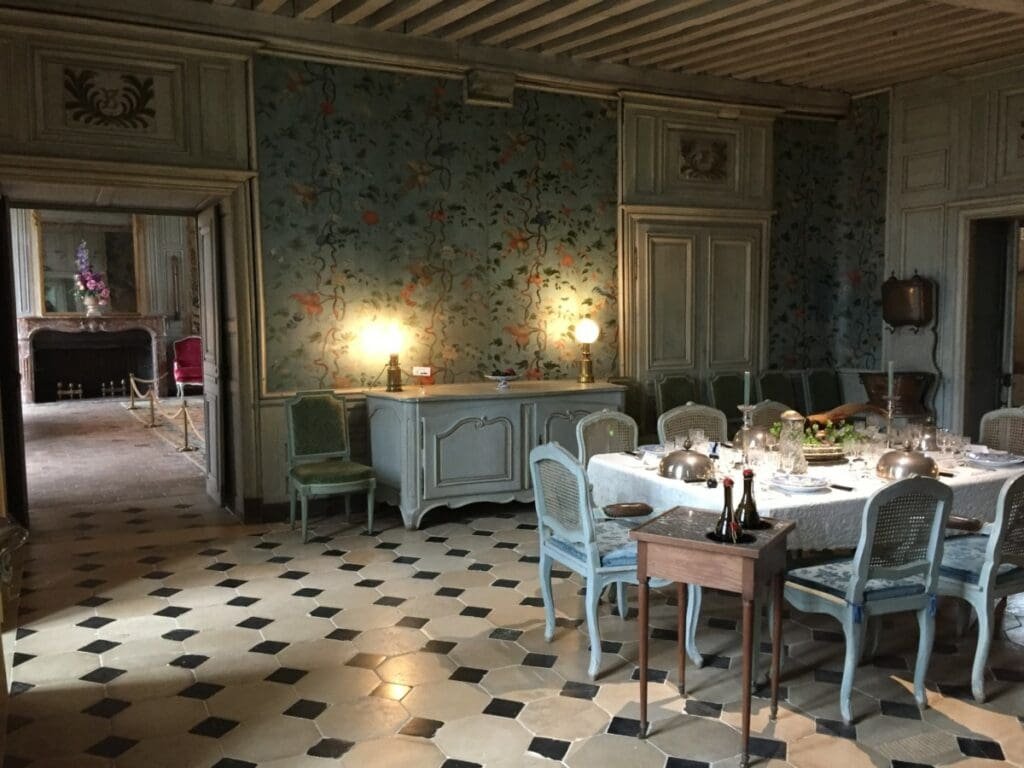 Salle à manger historique du château de Talcy avec tapisserie et carrelage.