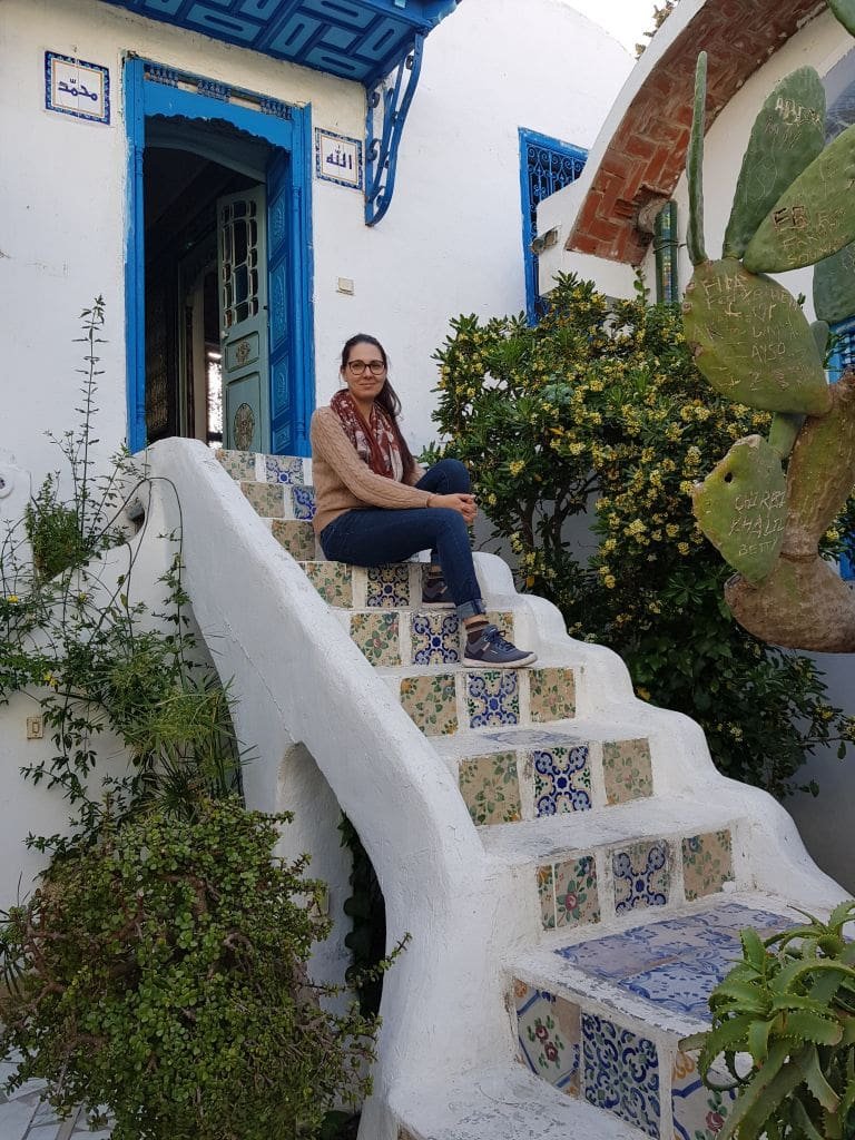 Musée Dar el-Annabi Sidi Bou Saïd - DR Melle Bon Plan 2019 Femme assise sur les escaliers en zellige d'une maison blanche typique de Sidi Bou Saïd.