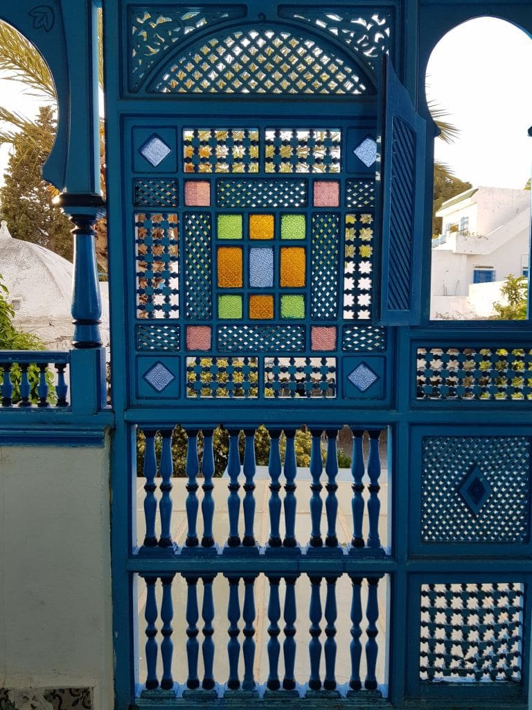 Moucharabieh bleu à Sidi Bou Saïd avec vitraux colorés.