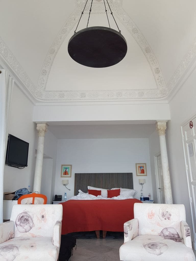 Villa Bleue Sidi Bou Saïd - DR Melle Bon Plan 2019 Chambre double à La Villa Bleue Sidi Bou Saïd avec lit rouge et lustre sombre.