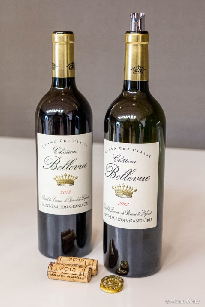 Two bottles of Château Bellevue Saint-Émilion Grand Cru 2012 wine with corks.