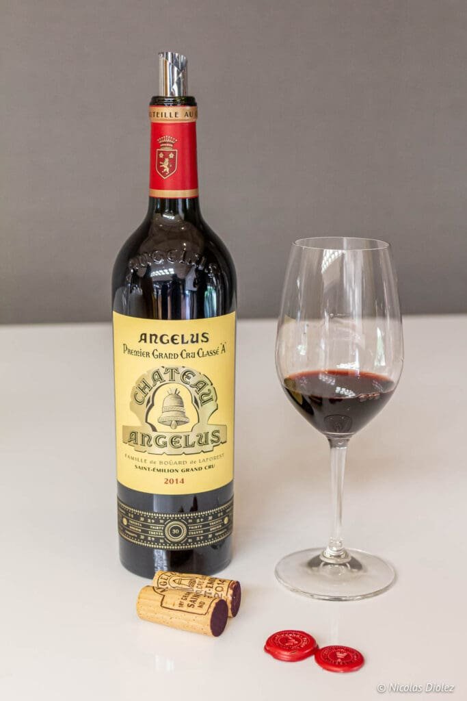 Bottle of Château Angélus Premier Grand Cru Classé A 2014 and glass of wine.