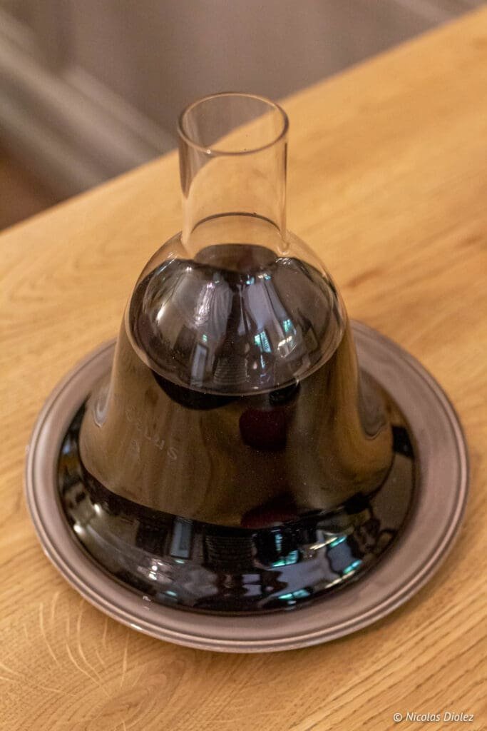 Bottle of Château Angélus red wine in a carafe on a tray.