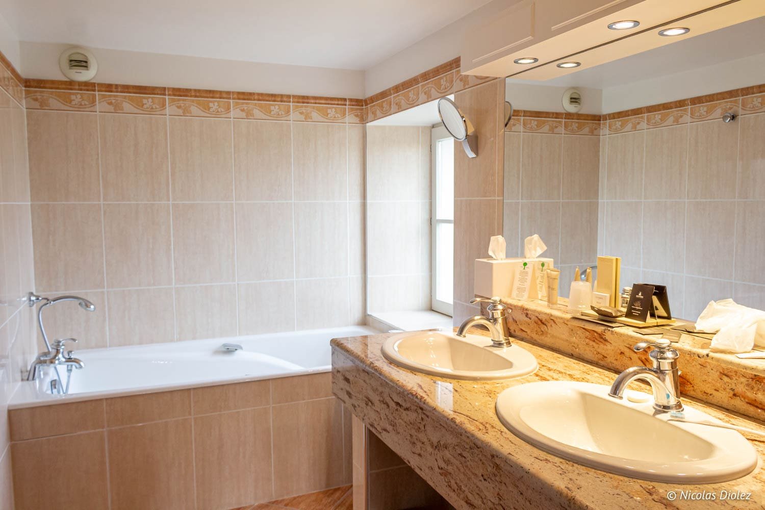 Badezimmer mit Doppelwaschbecken, Badewanne und Spiegel in einer Unterkunft in der Meuse.