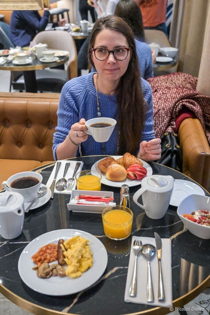 Femme prenant le petit déjeuner à l'Hôtel La Lanterne Paris.