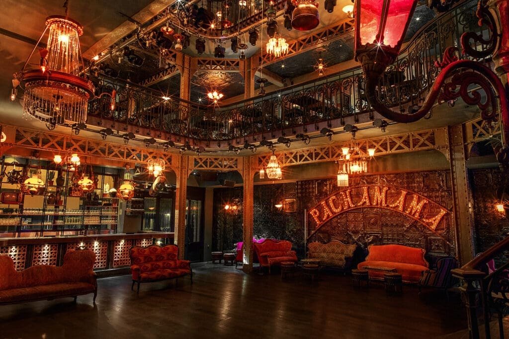 Cozy interior of the Pachamama Paris bar with neon and balconies.
