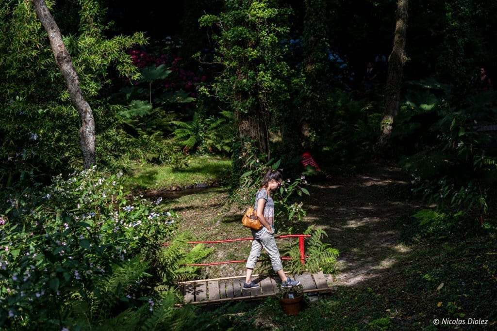 Femme traversant un pont dans le Jardin en Hommage à Jacques Prévert, Cotentin.