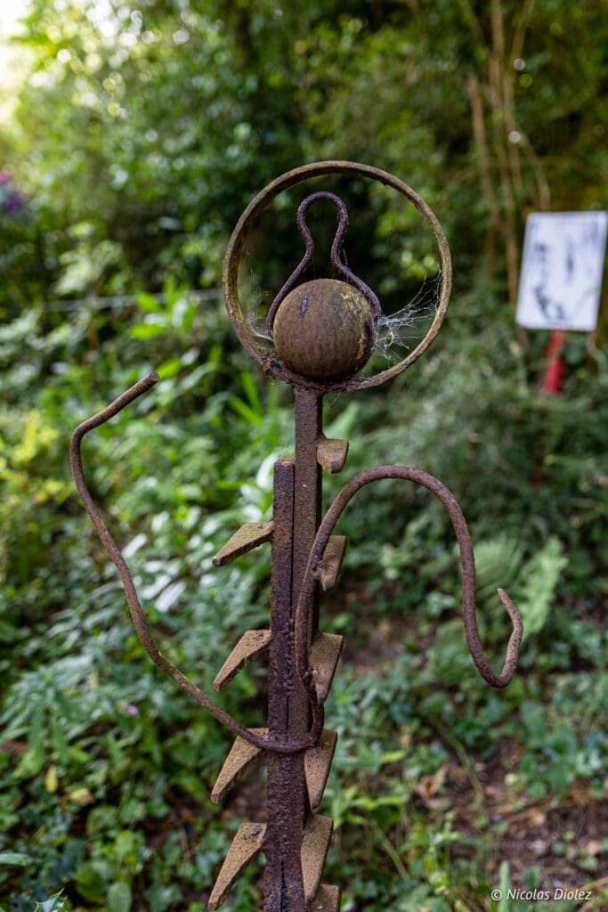 Sculpture rouillée en hommage à Jacques Prévert dans un jardin du Cotentin.