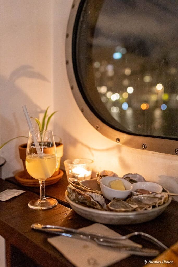 Huîtres et vin blanc dans un bar à vin flottant parisien (La Bougeotte).