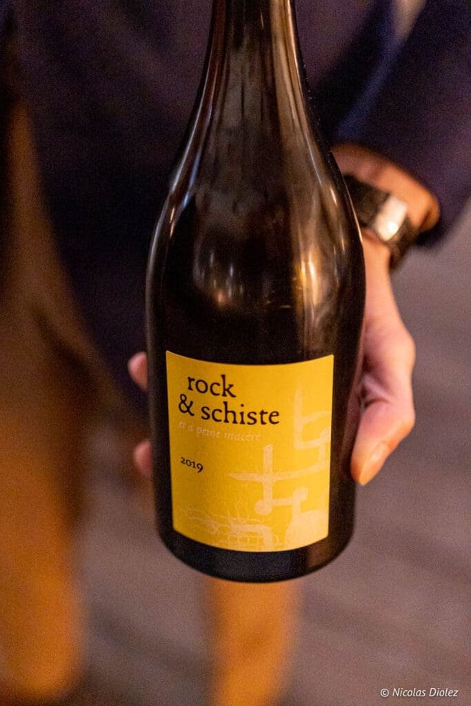 Bouteille de vin Rock & Schiste 2019 tenue à la main, bar à vin Paris.