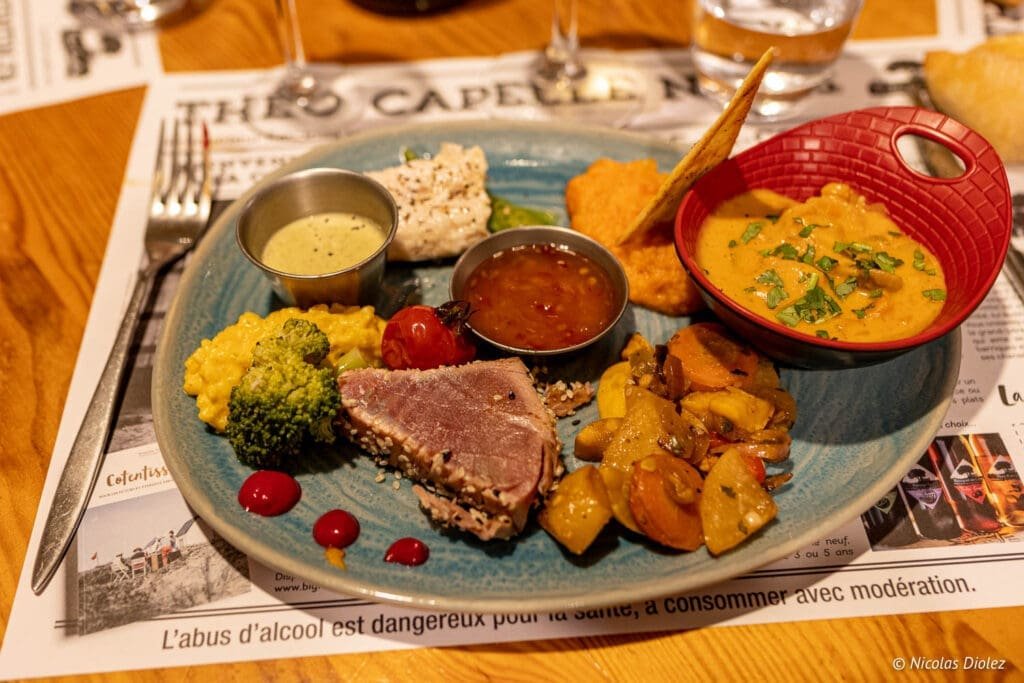 Assiette garnie: thon mi-cuit, curry, légumes et sauces, Restaurant La Malle aux Épices.