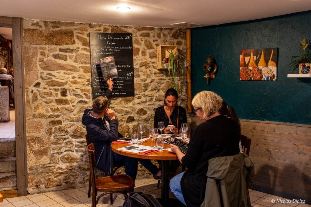 Intérieur restaurant La Malle aux Épices avec clients consultant le menu.