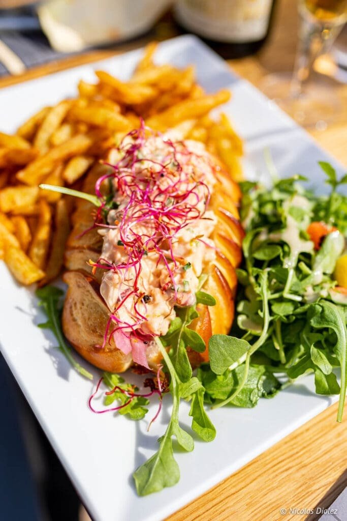 Lobster roll de L'Ô P'tit Crabe de Goury, frites et salade.