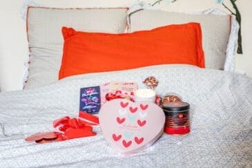 Boîte cœur Saint-Valentin Puyricard avec jeu et chocolats sur lit.