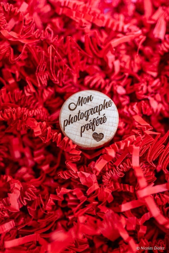 Médaillon en bois "Mon photographe préféré" sur fond de papier de soie rouge Saint-Valentin.