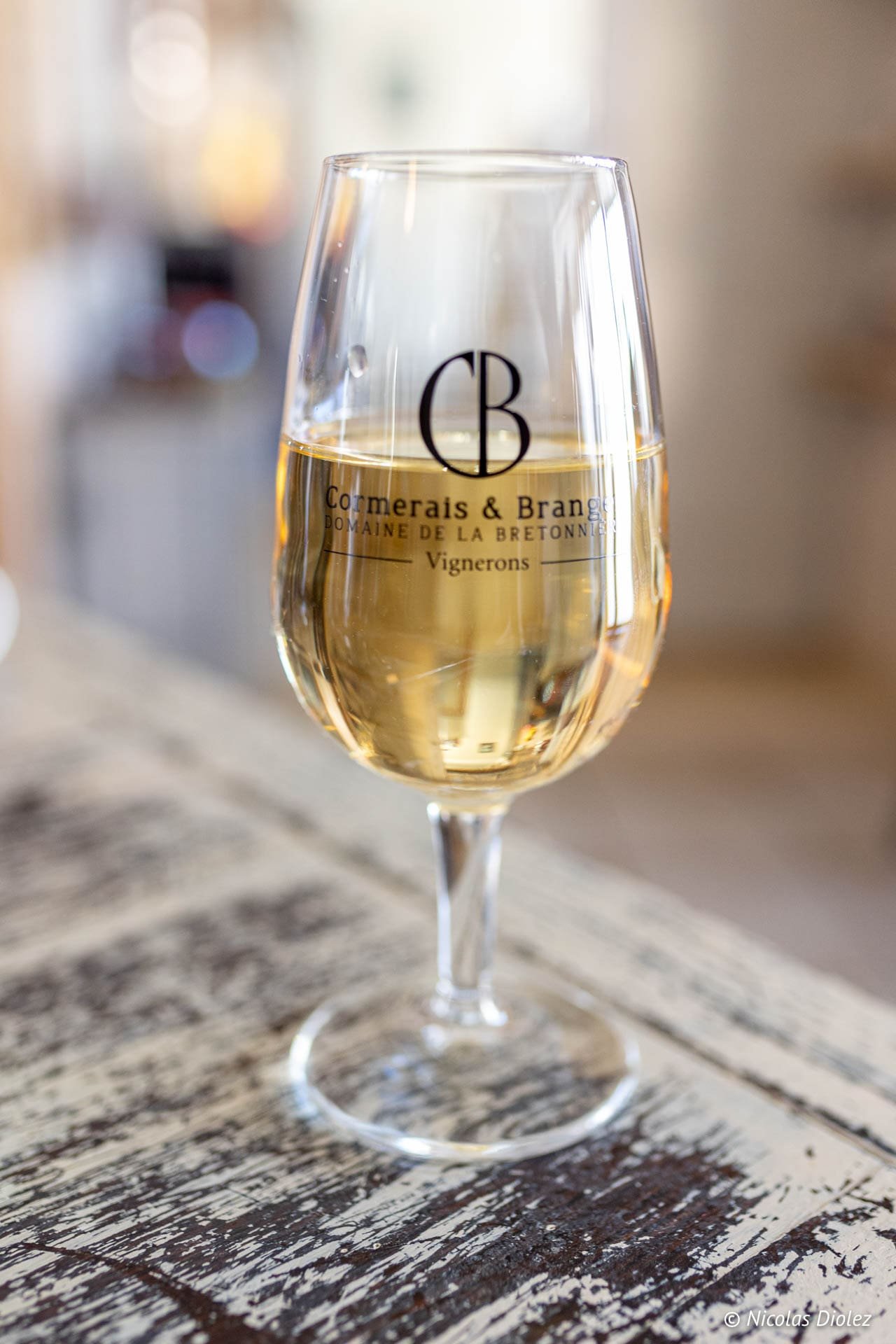 Verre de vin blanc Cormerais & Branger sur table en bois patiné Vosges.