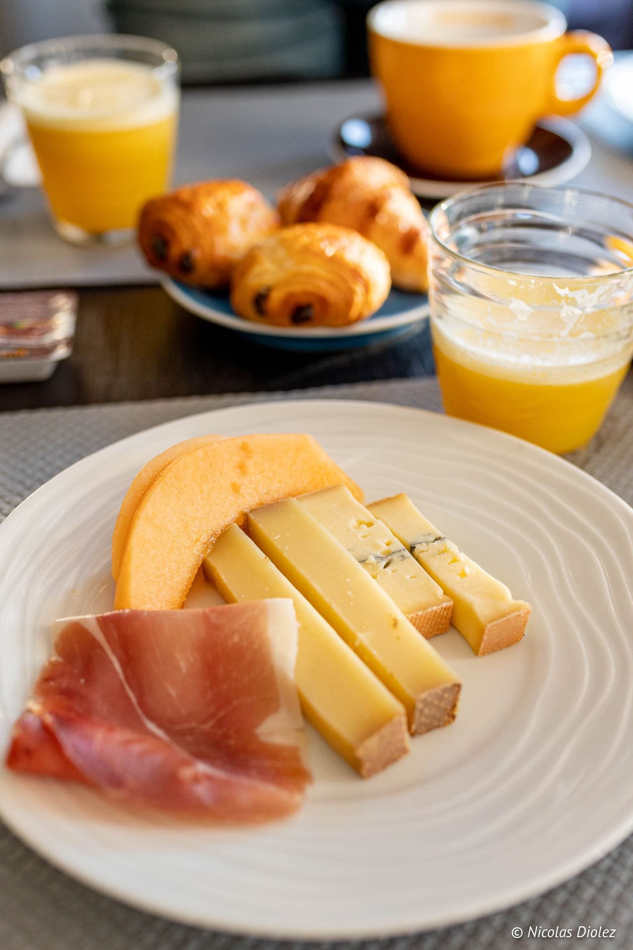 Petit déjeuner Hôtel Beau Site Luxeuil-les-Bains : jambon, fromages, melon, jus et viennoiseries.