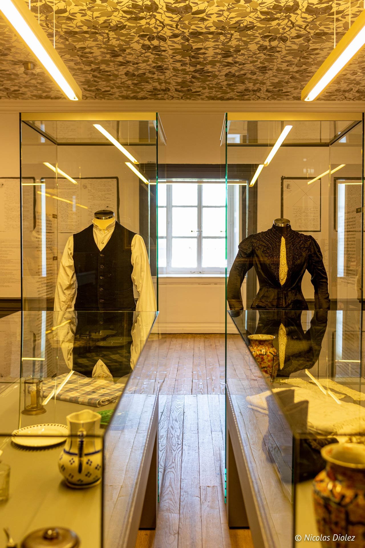 Vêtements d'époque dans vitrines à l'Écomusée du Pays de la Cerise, Vosges du Sud.