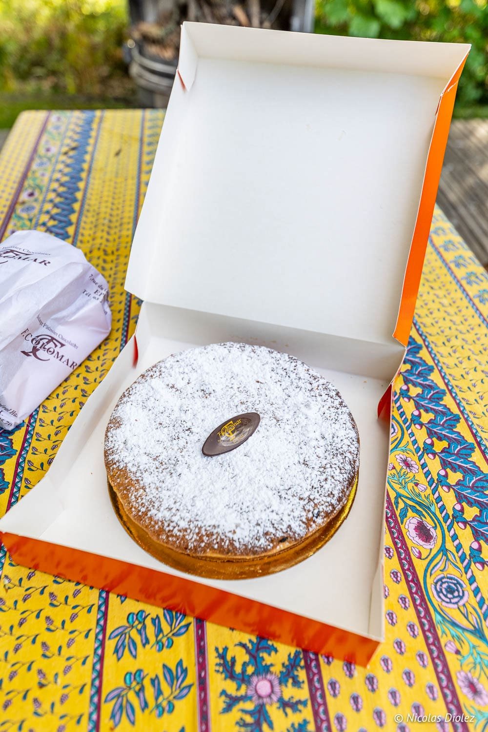 Tarte de F. Colomar Épinal avec sucre glace dans une boîte ouverte.