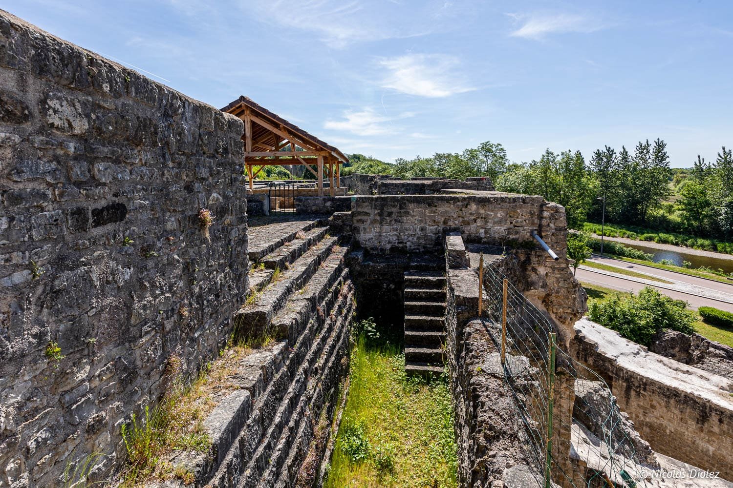 Ruines de la forteresse de Châtel-sur-Moselle avec escaliers en pierre et abri sous le ciel bleu.