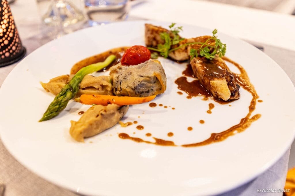 Plat gastronomique avec viande, légumes et sauce brune, bonne adresse Épinal.