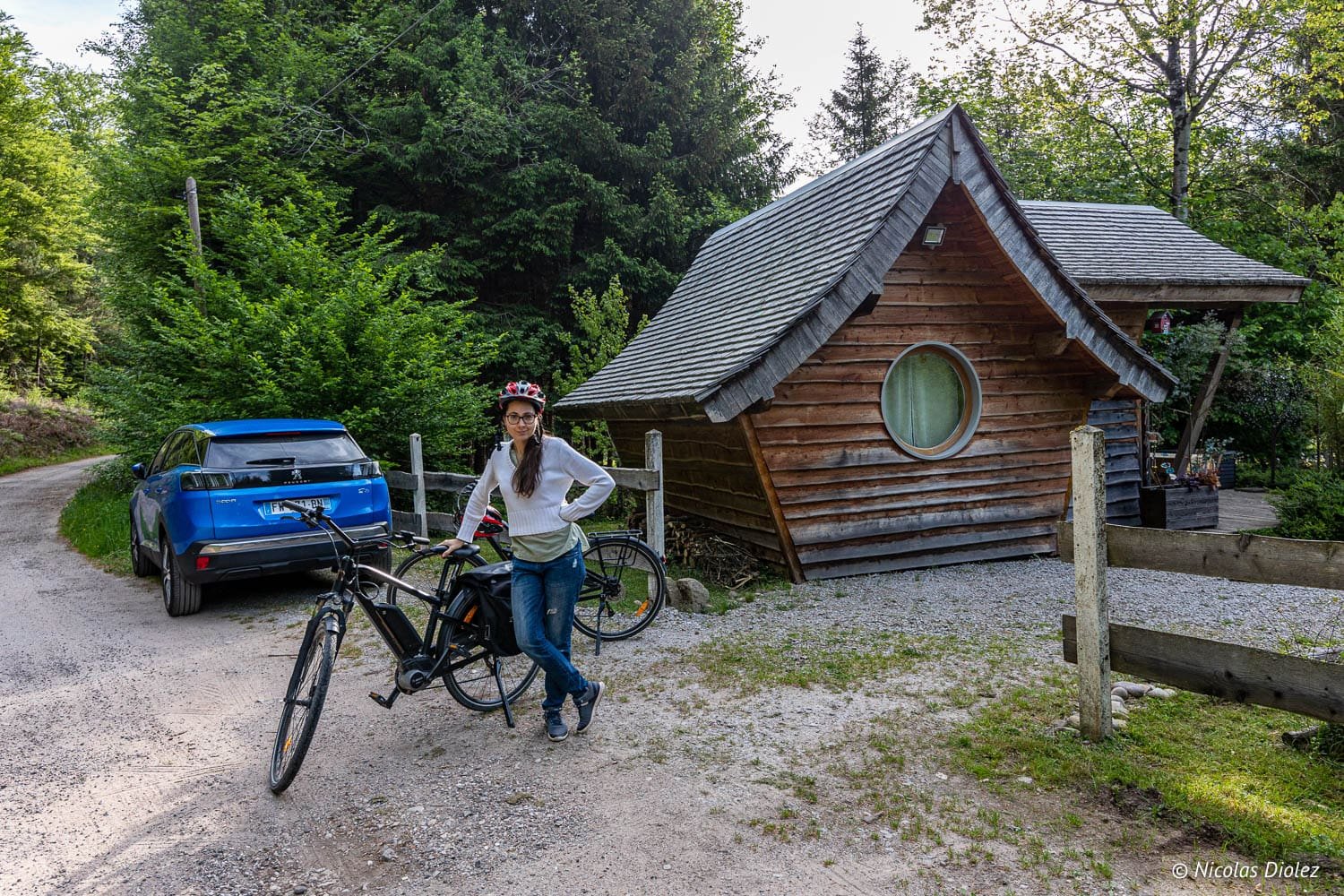 Cycliste avec vélo électrique près d'une cabane en bois durant une balade autour d'Épinal.