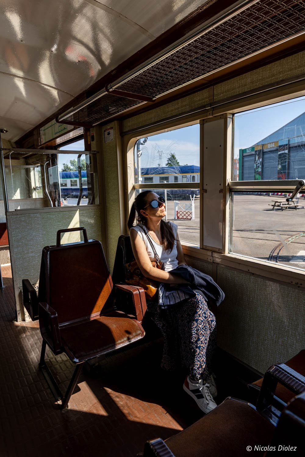 Femme profitant du soleil dans une voiture au Musée de la Cité du Train Mulhouse.