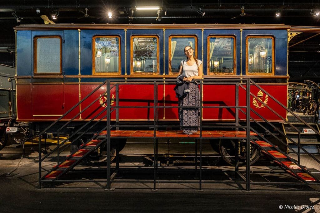 Visiteuse devant un wagon historique de luxe à la Cité du Train de Mulhouse.