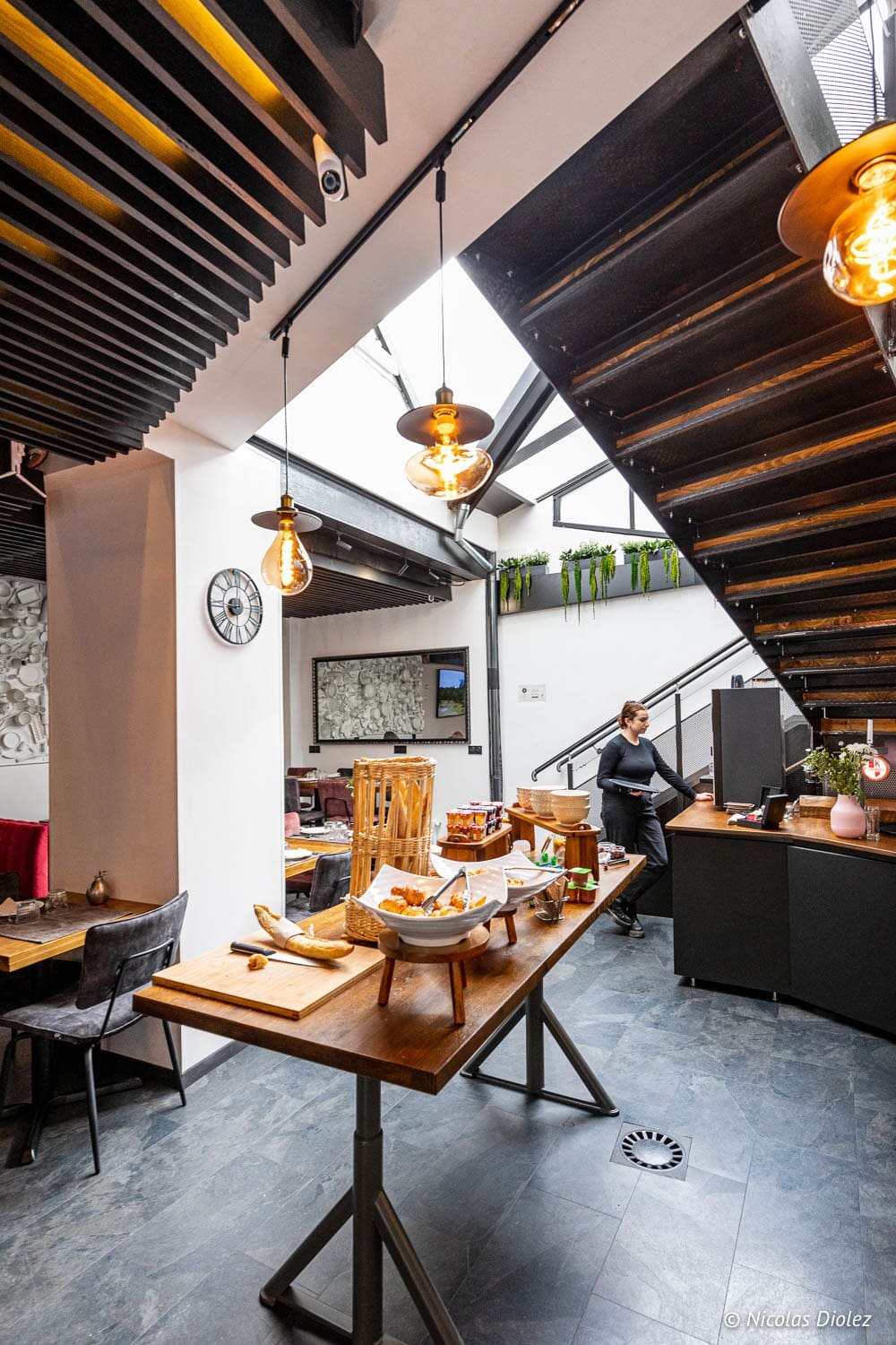 Buffet petit-déjeuner moderne dans un hôtel de Mulhouse avec escalier métallique.
