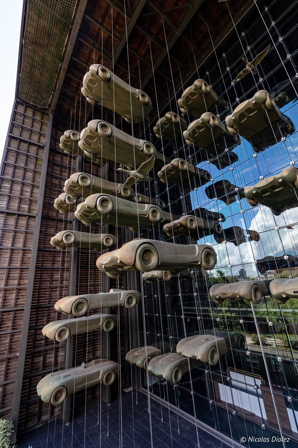 Sculptures de voitures suspendues à la façade vitrée du Musée National de l'Automobile à Mulhouse.
