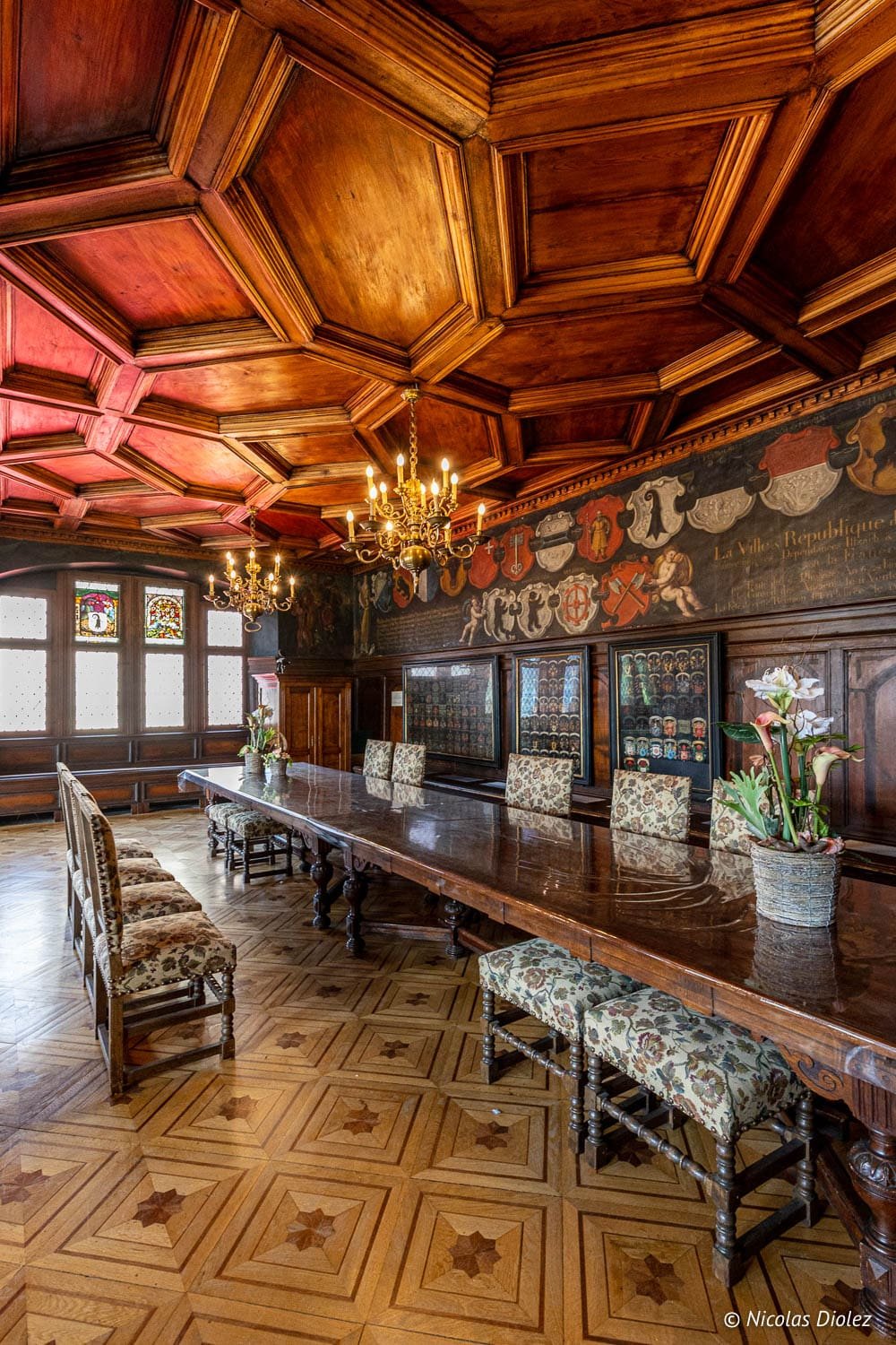 Salle du Musée Historique de Mulhouse avec plafond boisé et grande table.