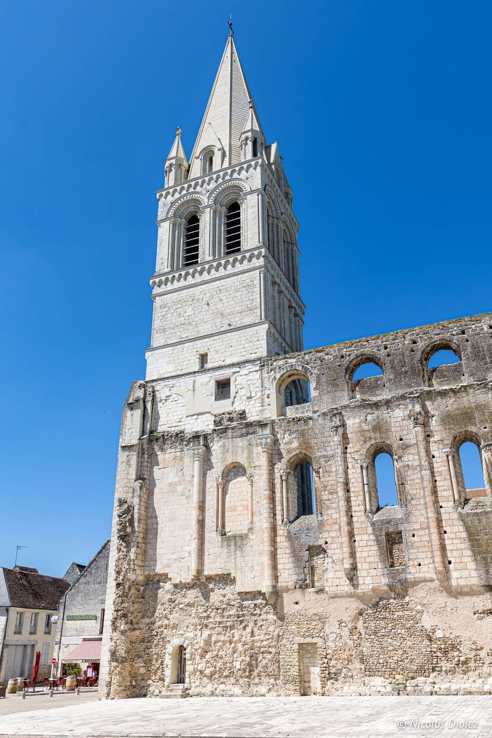 Clocher de l'ancienne église de Beaulieu-lès-Loches, façade en ruine, ciel bleu.
