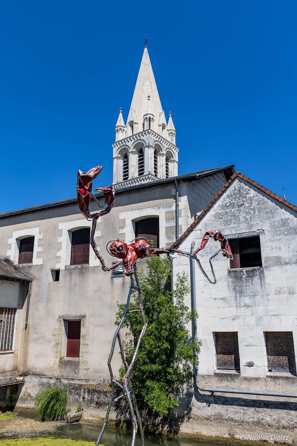 Sculpture d'insecte rouge près de la flèche de l'église à Beaulieu-lès-Loches.