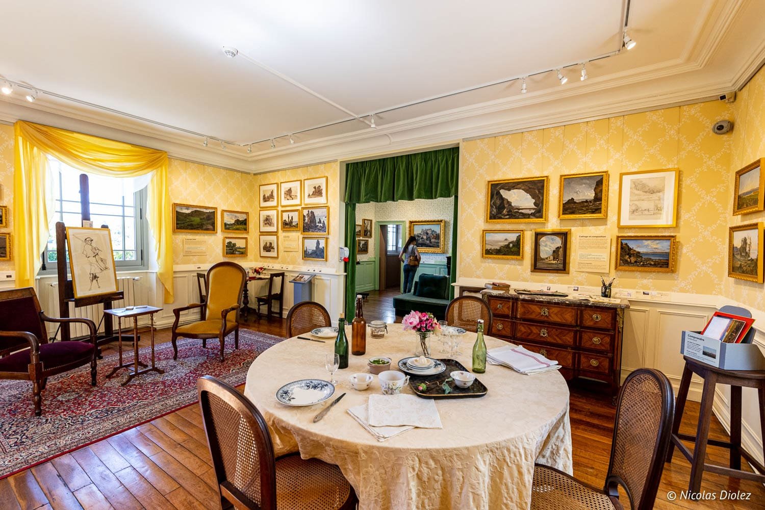 Intérieur du Musée Lansyer à Loches avec table dressée et tableaux muraux.