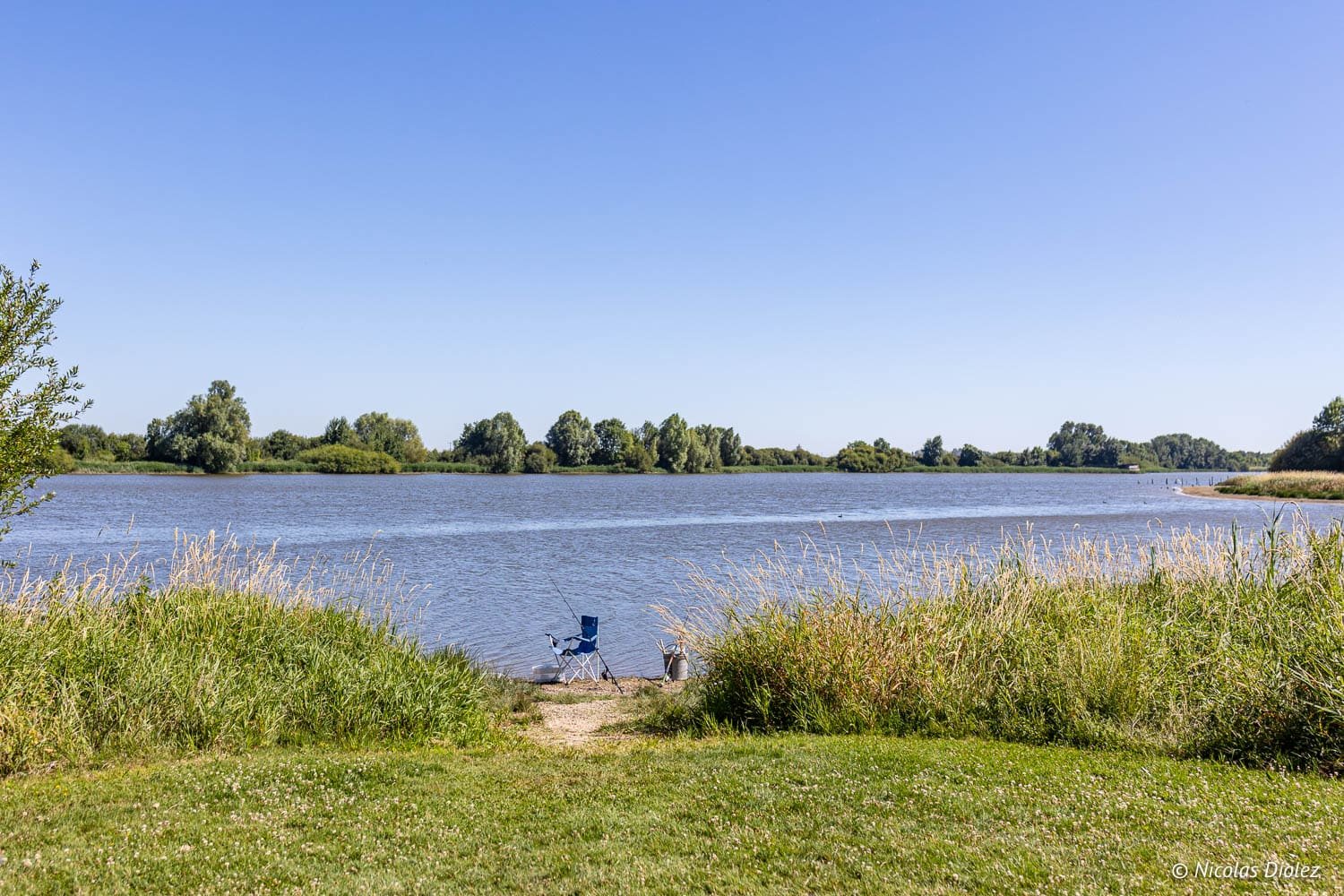 Pêche au bord d'un plan d'eau avec chaise et canne à pêche, Sud Touraine.