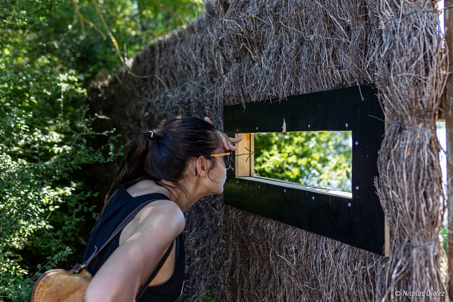 Randonneuse regardant à travers une cachette naturelle, Loches Sud Touraine.