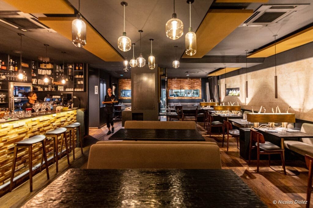 Serveuse marchant dans l'intérieur moderne du restaurant Épicurien à Albi.