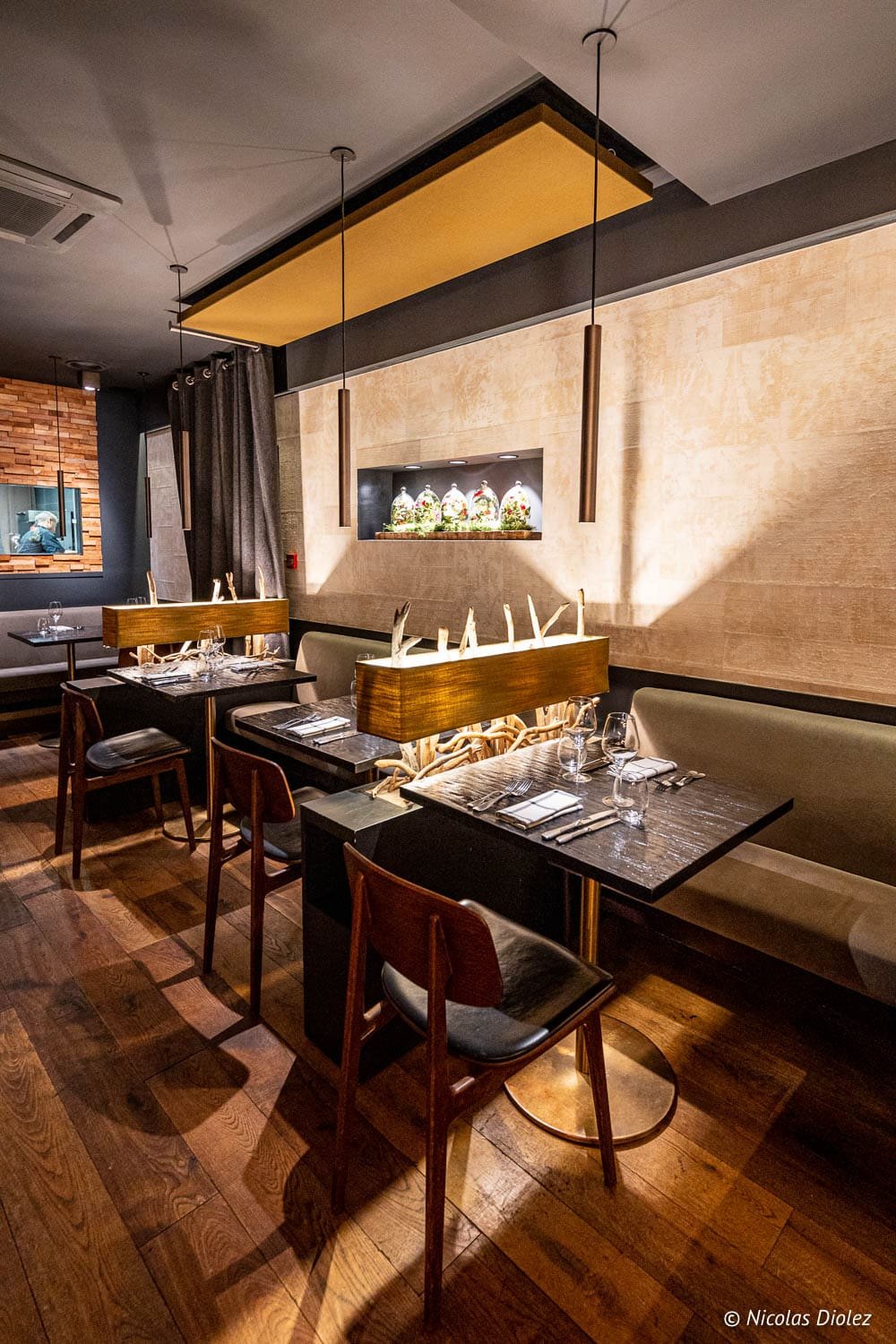 Intérieur restaurant Épicurien Albi, tables dressées, éclairage chaleureux, décoration bois et pierre.