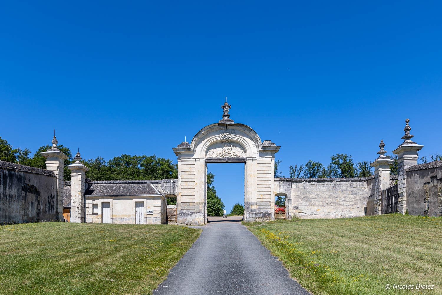 Portail monumental de la Forêt de Loches sous un ciel bleu.
