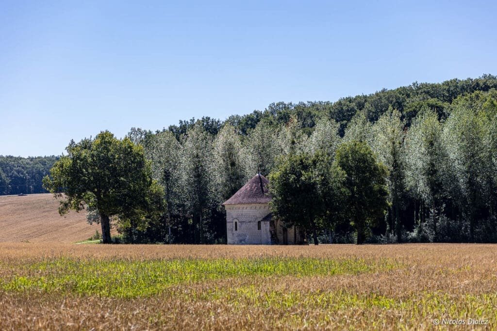 Chapelle romane isolée dans un champ de blé près de la forêt de Loches.