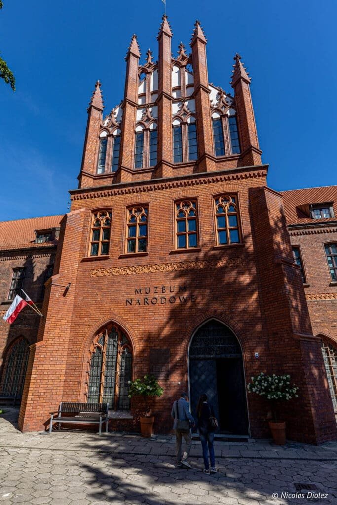 Façade en briques du Muzeum Narodowe (Musée National) de Gdańsk sous le ciel bleu.