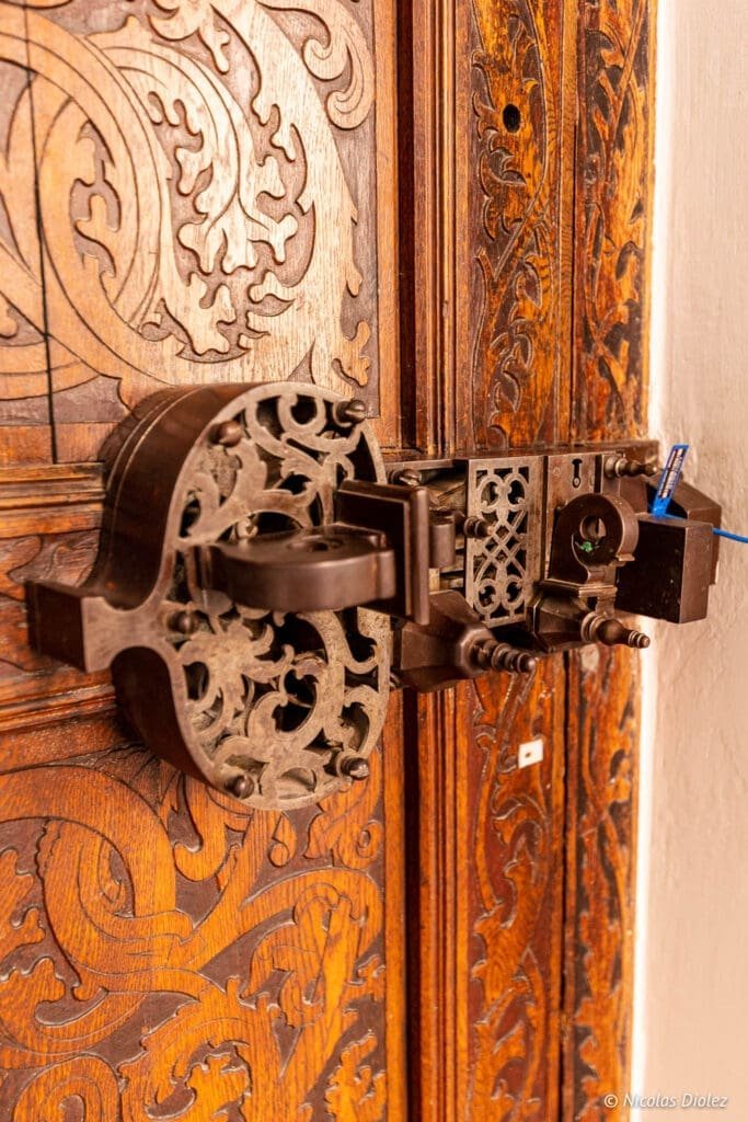 Serrure ancienne ornementée sur porte sculptée du Musée National de Gdańsk.