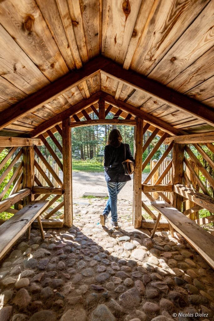 Femme sortant d'un abri en bois au Parc Ethnographique de Kaszuby en Poméranie.